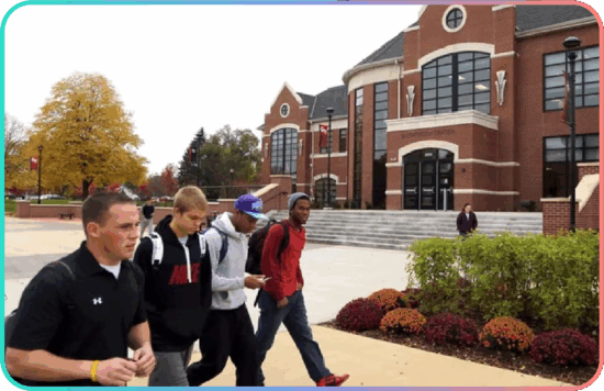 Grand View University students walking past a brick campus building