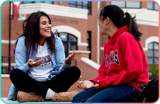 Grand View University students chatting on a campus lawn